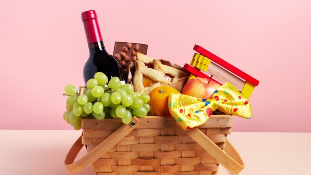 Mishloach Manot Basket with wine, grapes, oznei haman, gragger, and more